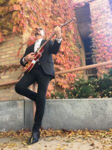 A man in a suit and tie playing an instrument.