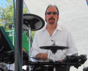 A man playing drums in front of an audience.