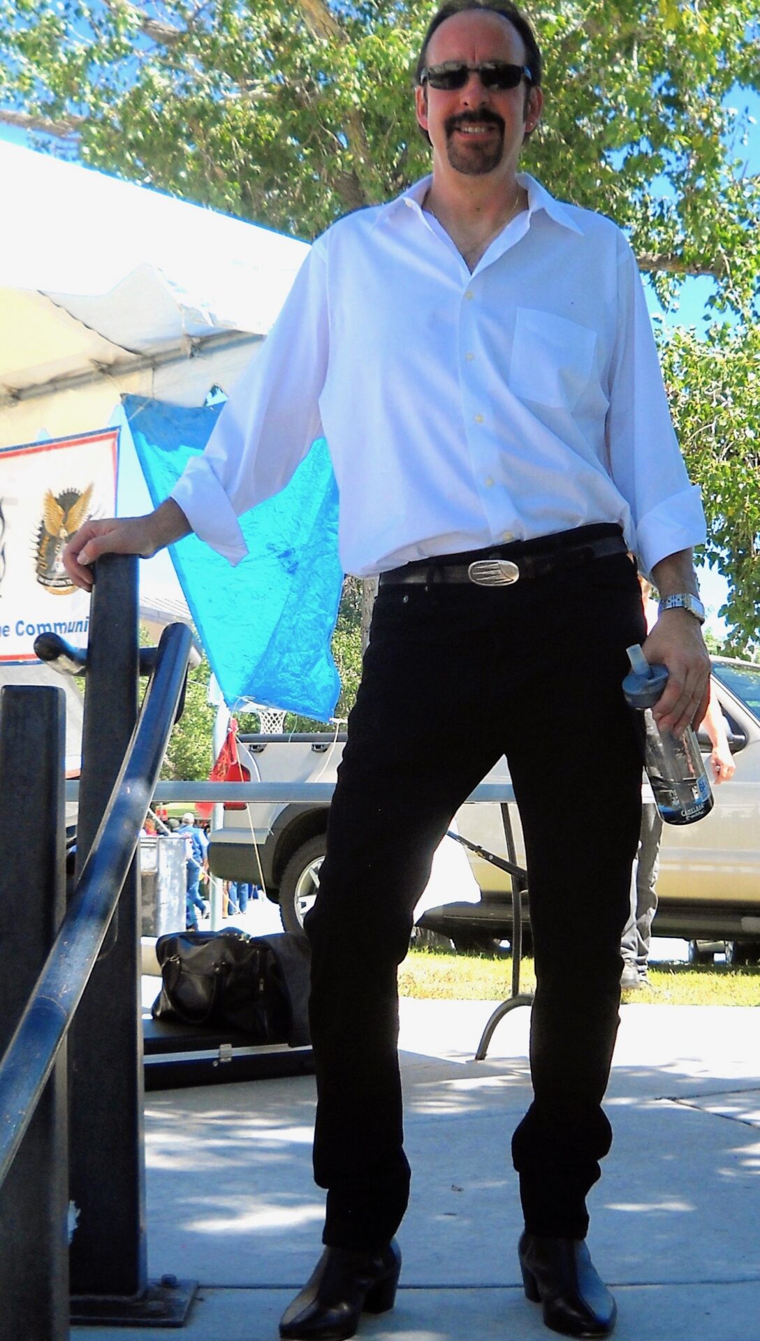 A man in white shirt holding a blue umbrella.